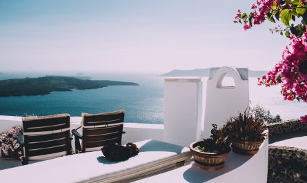 two brown wooden chairs beside the wall